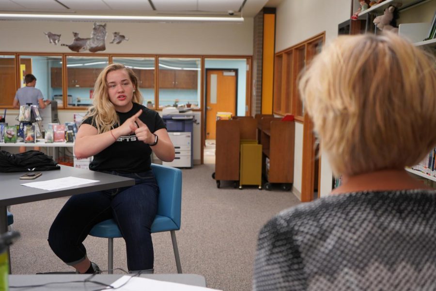 Senior Ella Backauskas practices her sign language skills with Sign Language Club sponsor Mrs. McAfee.  I taught my mom and brother a little bit, so sometimes we just sign to each other for fun, Backauskas said.