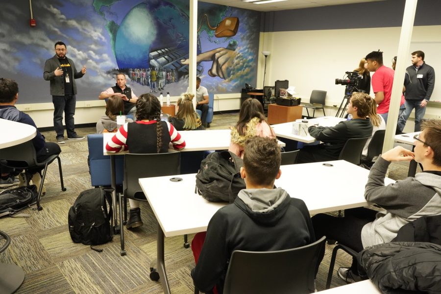 Business teacher Mr. Langue introduces his students to the Troutwood investment team just before the group turned on the cameras and microphones to record a podcast in the library.