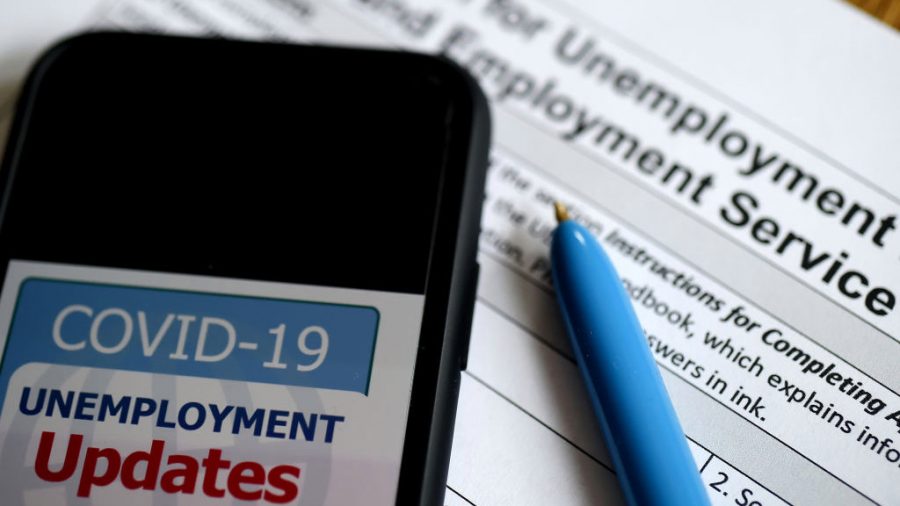 In this photo illustration, a COVID-19 Unemployment Assistance Updates logo is displayed on a smartphone on top of an application for unemployment benefits on May 8, 2020, in Arlington, Virginia. - With shops and factories closed nationwide due to the coronavirus pandemic, nearly all of the jobs created in the US economy in the last decade were wiped out in a single month. An unprecedented 20.5 million jobs were destroyed in April in the worlds largest economy, driving the unemployment rate to 14.7 percent compared to 4.4 percent in March, the Labor Department said in its monthly report, the first to capture the impact of a full month of the lockdowns. (Photo by Olivier DOULIERY / AFP) (Photo by OLIVIER DOULIERY/AFP via Getty Images)