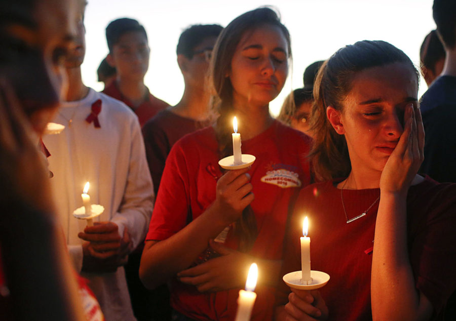 Students gather to grieve during a vigil at Pine Trails Park for the victims of the Wednesday shooting at Marjory Stoneman Douglas High School, in Parkland, Fla., Thursday, Feb. 15, 2018. Nikolas Cruz, a former student, was charged with 17 counts of premeditated murder on Thursday. (AP Photo/Brynn Anderson)