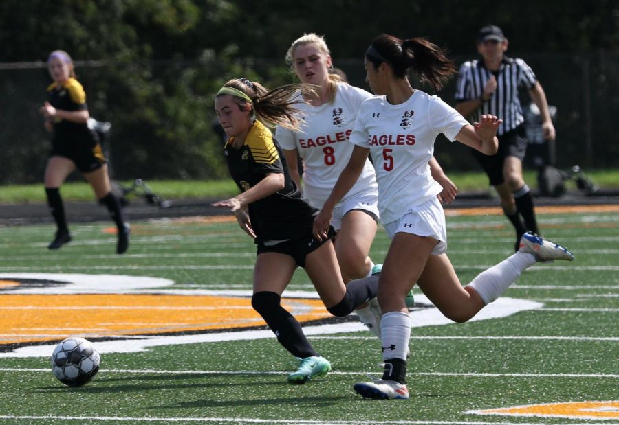 Junior Lucia Wells dribbles past two defenders to get a shot off on goal. 