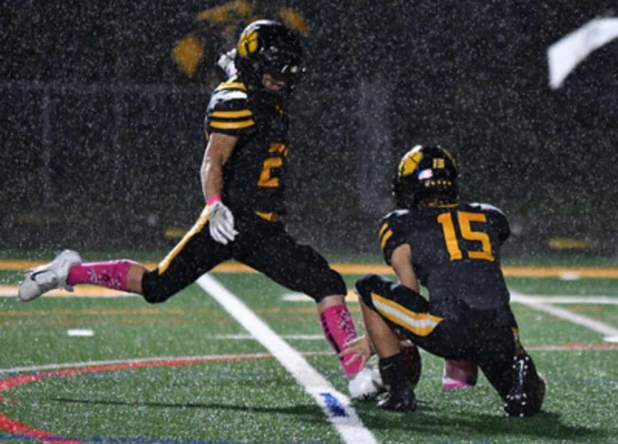 Harron Lee kicks a field goal in the rain during a home Pink Out game