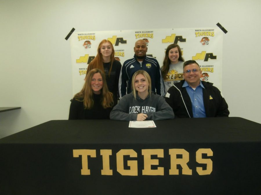 Megan+Miller%2C+flanked+by+her+coaches+and+her+family%2C+is+one+of+the+many+student+athletes+to+have+signed+her+letter+of+intent+to+continue+her+athletic+career+at+the+collegiate+level.+