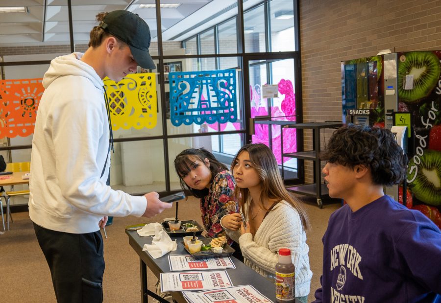 NASH senior Rourke Kennedy registers to vote during lunch on Thursday.  The voter registration table was initiated by junior Collin Wang (right), with the help of seniors Zoe Ky (left) and Georgia Moniaga (center).