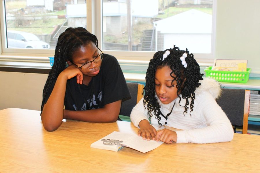 NASH senior Tabo Mckandawire and her Grandview student Viviette read together in the Grandview Library. 