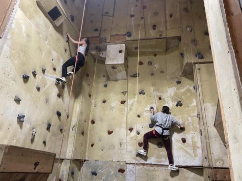 Milanna Habib (left) and Sophie Azar scale the rock wall during their period 4 gym class.