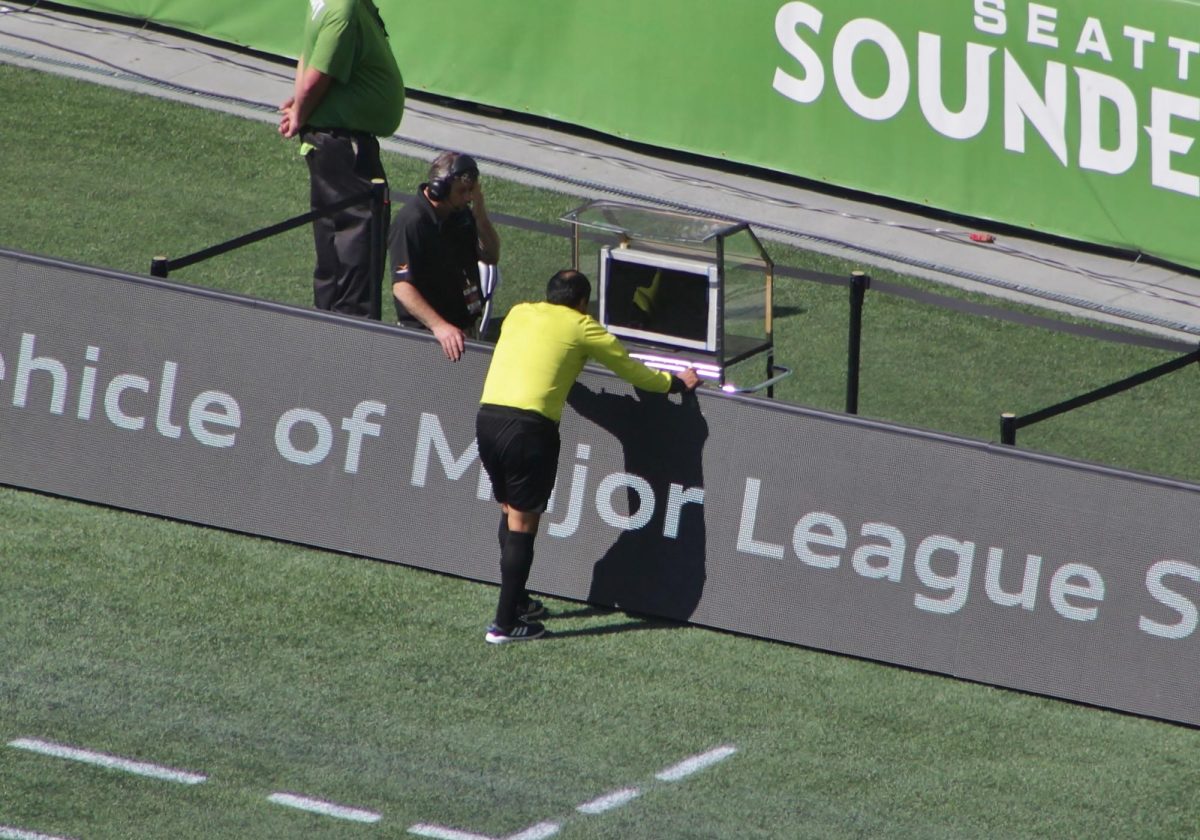 Referee Baldomero Toledo consults the video assistant referee during a Major League Soccer match between Seattle Sounders FC and Sporting Kansas City at CenturyLink Field. 