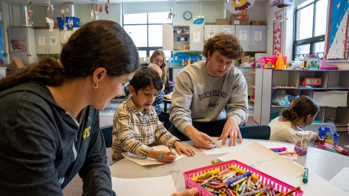 NASH seniors Elliana Vitale and Jack Ferraro color with an afternoon preschooler.